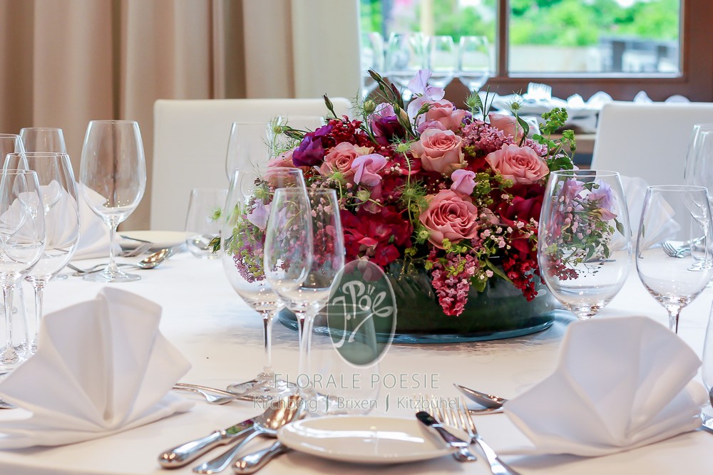 Tischdekoration mit Blumen und Kerzen für eine Hochzeit